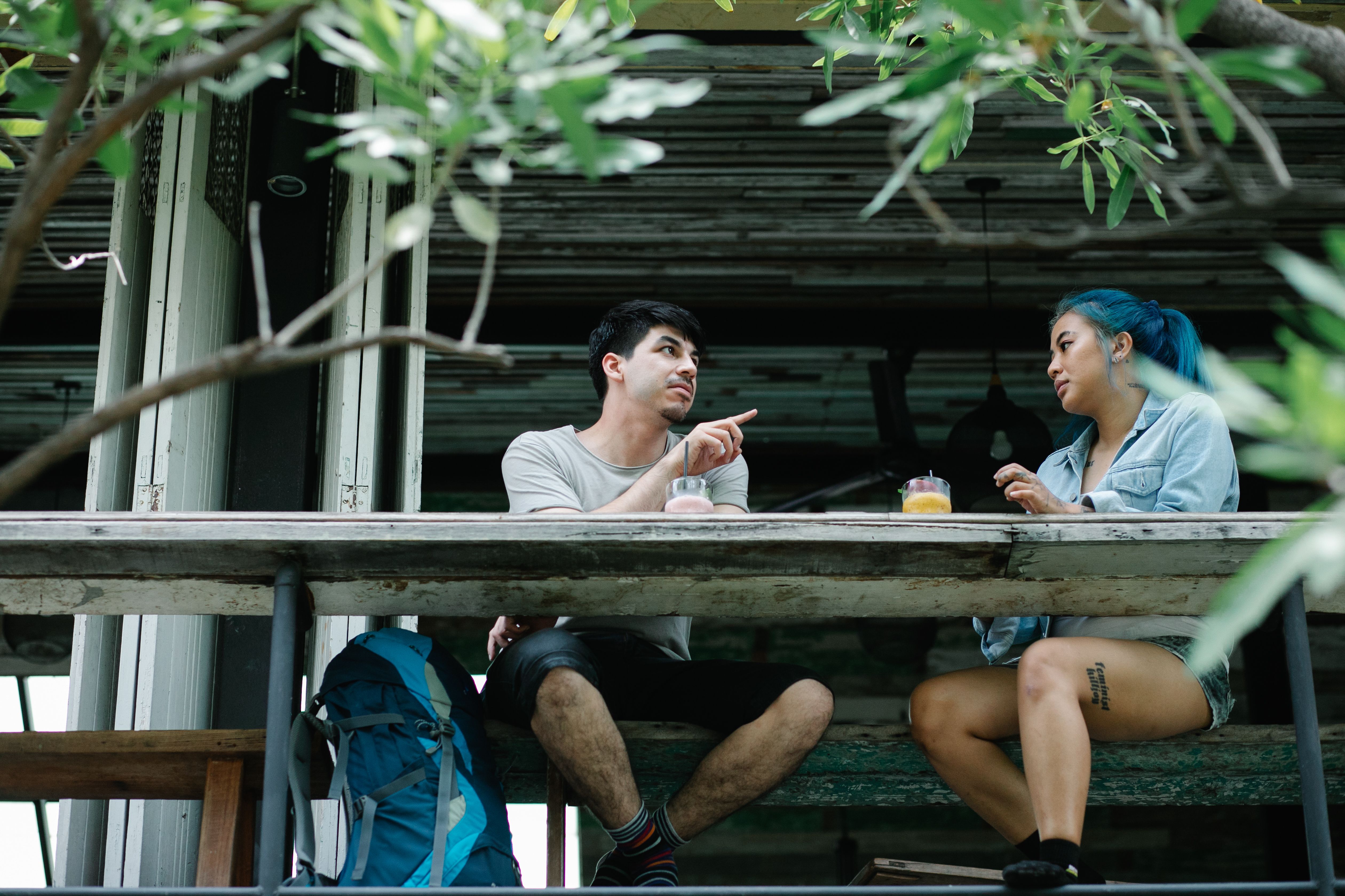 Couple enjoying drinks and conversation at an outdoor cafe table, active listening on a first date