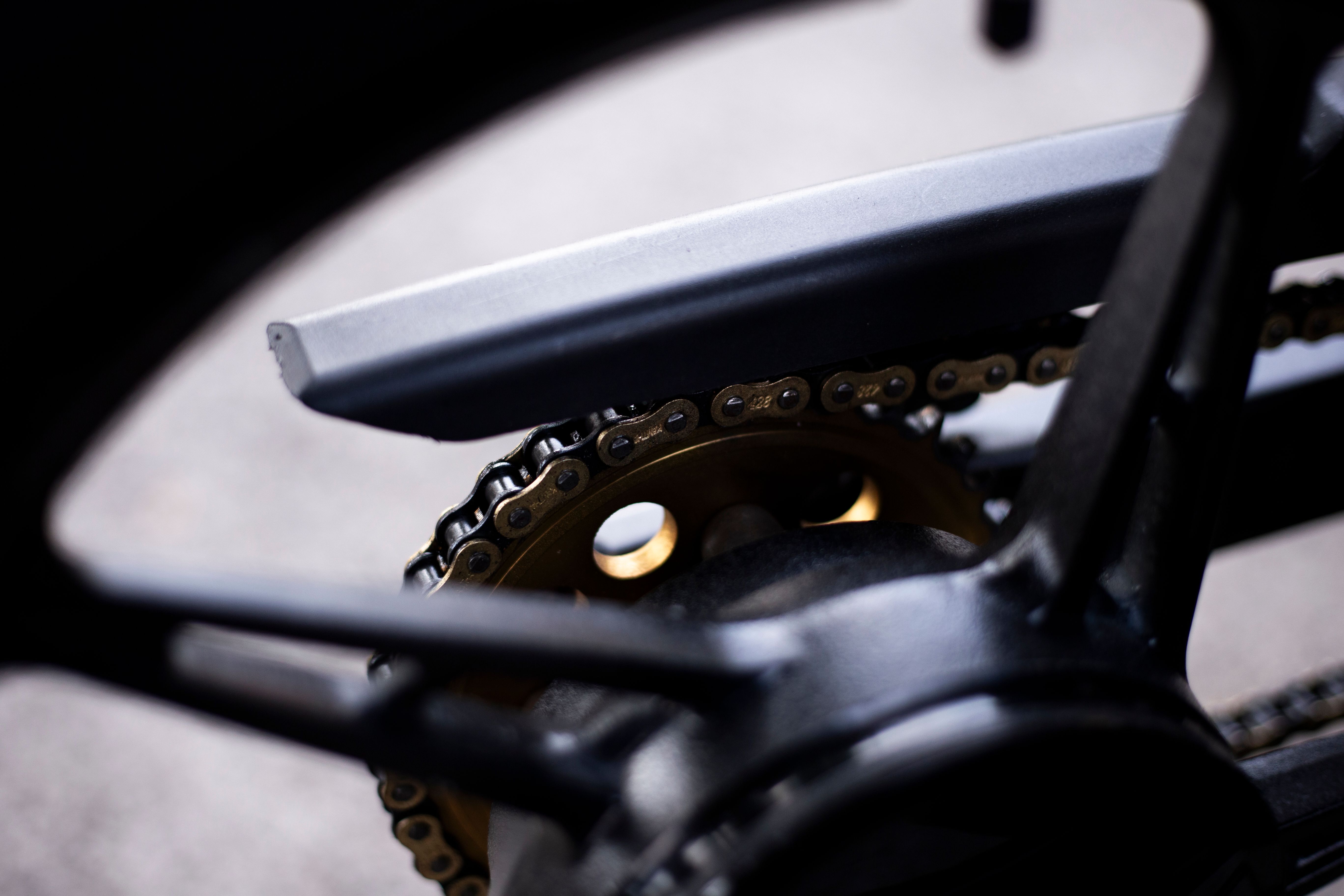 Detailed view of a motorcycle chain and sprocket needing regular lubrication and maintenance