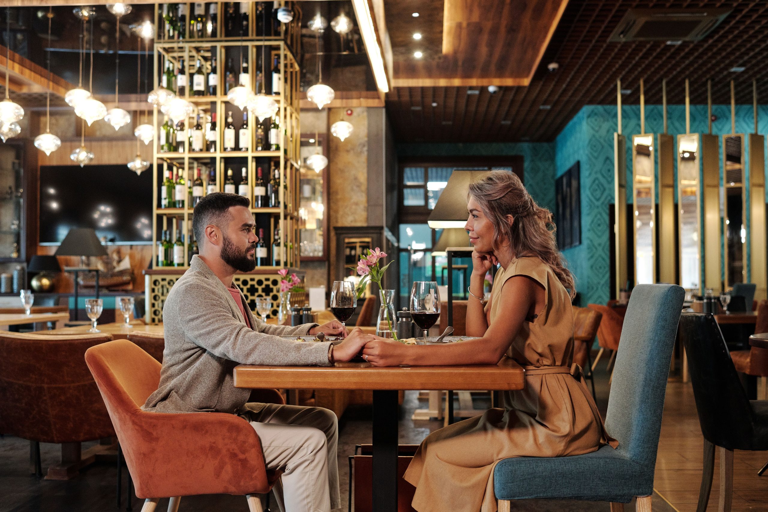 Couple enjoying a romantic dinner date with wine in an elegant restaurant setting, warm atmosphere